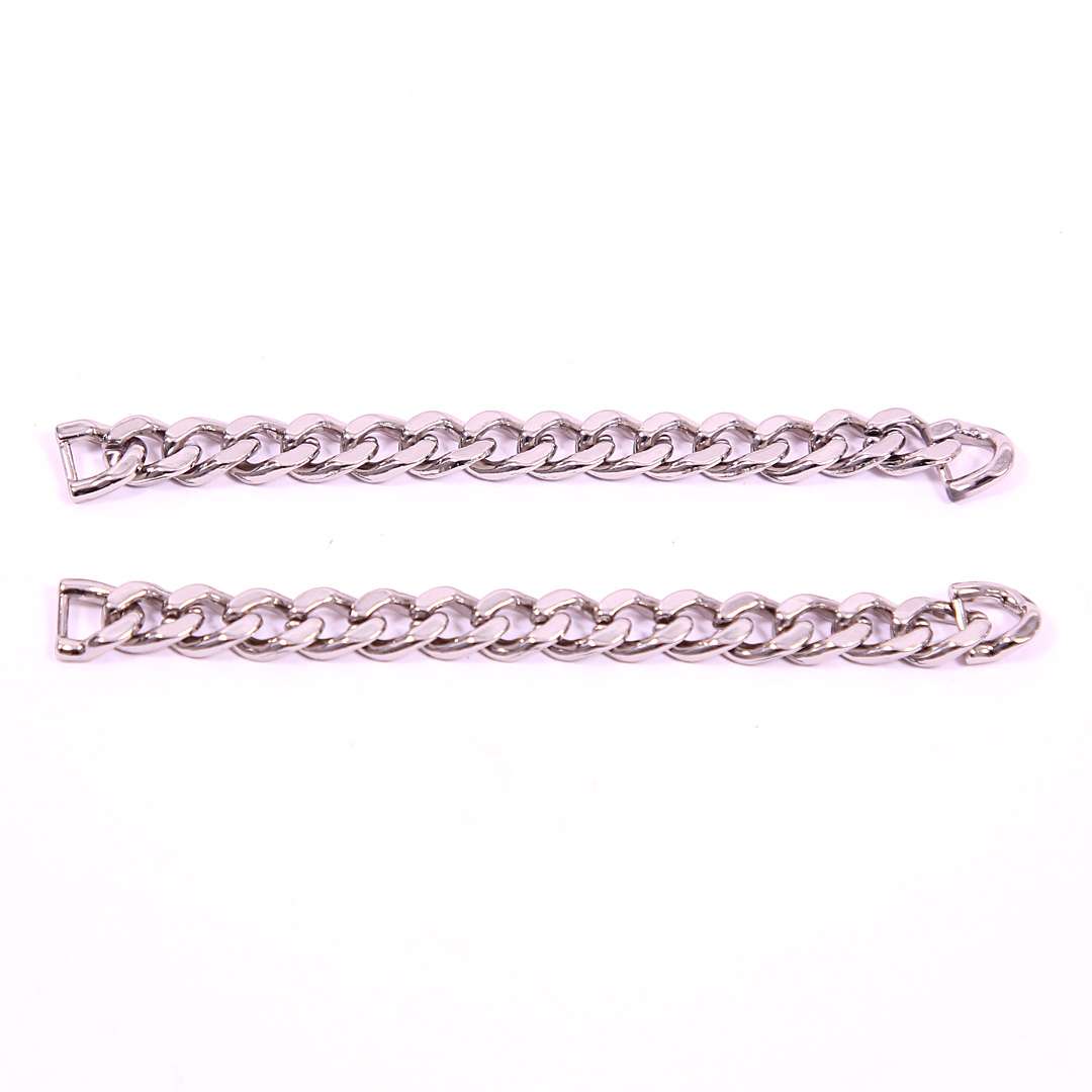 Two silver Cuban link sneaker chains laid out on a white surface.